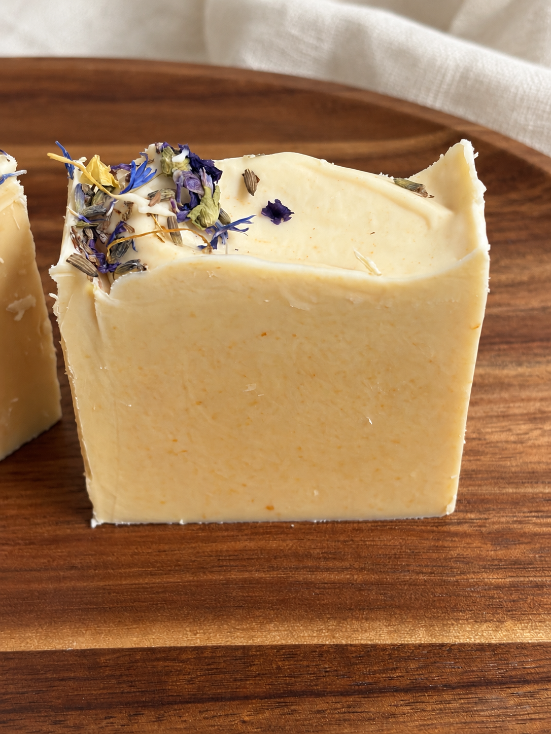 Midnight Garden honey and beeswax soap close-up showing handmade texture with blue, purple and golden botanical tops